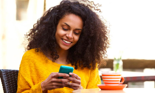 smiling woman typing on her phone