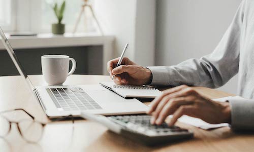 person's hands shown working at a desk