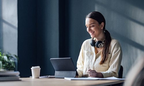 smiling woman typing on a laptop