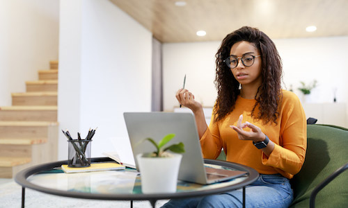 A woman sits in front of a laptop computer