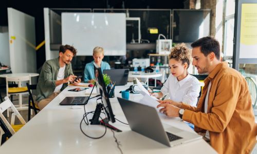 Tech workers collaborating in an open-office environment.