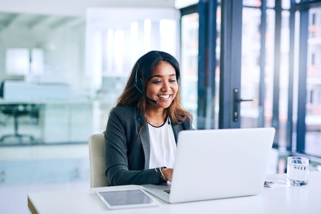 Partner wearing a headset, training on her laptop at an office.