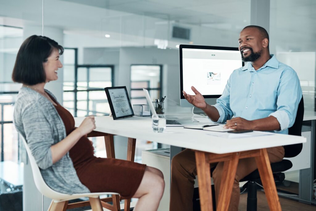 Two professionals a at a desk. Manager performance review.