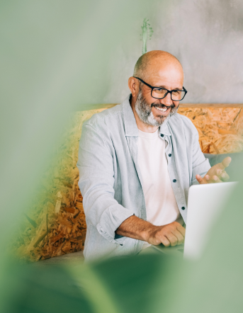 man sitting at table working on laptop